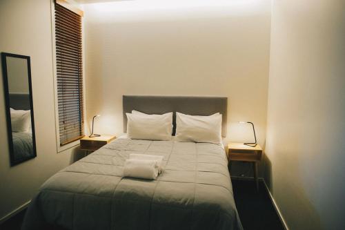 a bedroom with a large bed with two lamps on it at Liberty Apartment Hotel in Wellington
