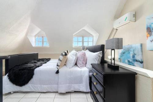 1 dormitorio con 1 cama con sábanas y almohadas blancas en Vacay with Tiffany, en Kingston