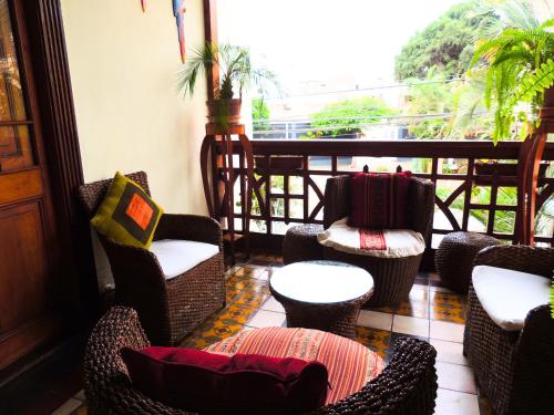 a porch with chairs and tables and a balcony at Lima Wari Hotel Boutique in Lima