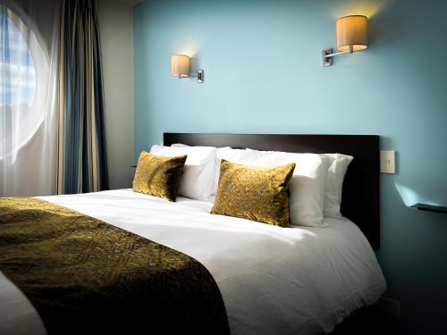 1 dormitorio con 1 cama grande con almohadas amarillas en Beaches Nelson, en Nelson