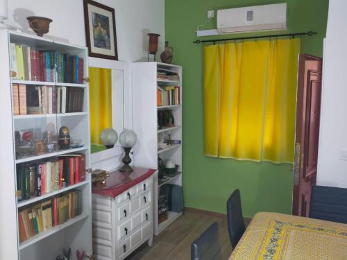 a room with a table and book shelves with books at Apto a 5 min a pie de la playa in Málaga