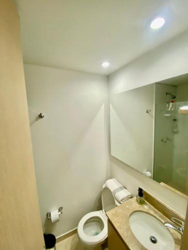 a bathroom with a toilet and a sink and a mirror at Apartamento luxury en sabaneta in Sabaneta