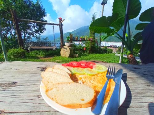 a plate of food with bread and tomatoes on a table at Sapa terraces in Sa Pa