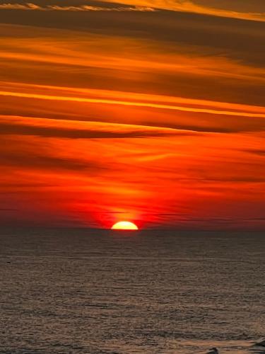 a sunset over the ocean with the sun in the sky at Your Beach Therapy Awaits at Sans Souci in Pensacola Beach