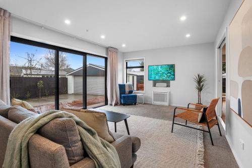 a living room with a couch and a tv at Private Family 4BR Home, Near Airport, Free Parking in Christchurch