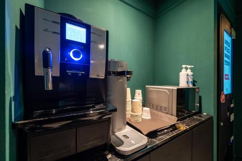 a room with a counter with a computer and a microwave at Wonju Hotel Ippda in Wonju