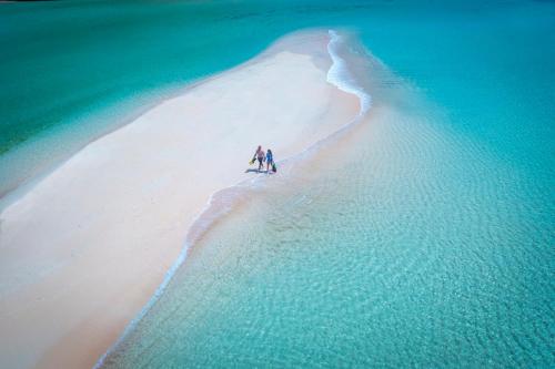 Due persone in piedi su una spiaggia nell'oceano di InterContinental Fiji Golf Resort & Spa, an IHG Hotel a Natadola