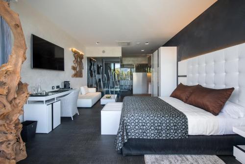 a bedroom with a king sized bed and a living room at Suites Natura Mas Tapiolas in Santa Cristina d'Aro