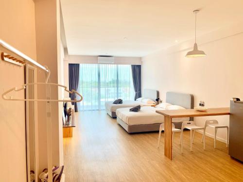a hotel room with two beds and a table at Deco Home @ Aru Suites in Kota Kinabalu