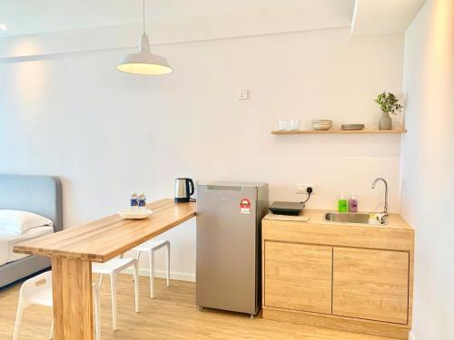 a small kitchen with a table and a refrigerator at Deco Home @ Aru Suites in Kota Kinabalu