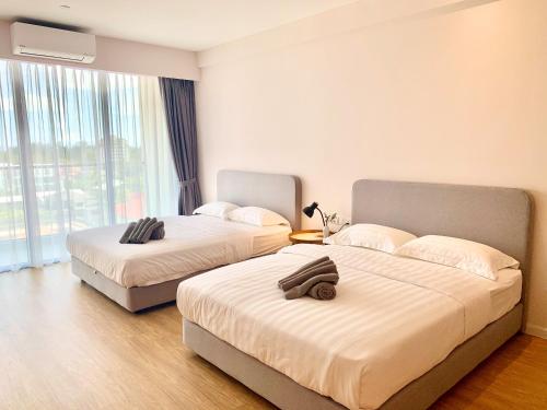 a hotel room with two beds and a window at Deco Home @ Aru Suites in Kota Kinabalu