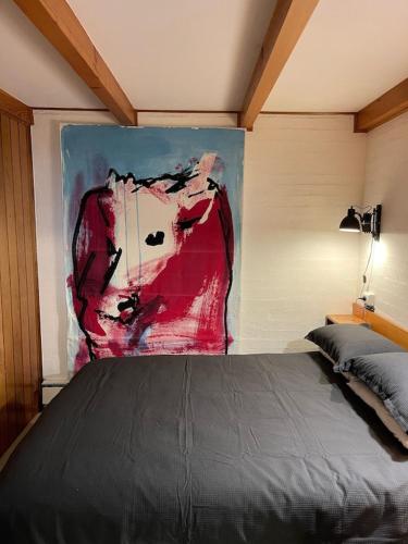 a bedroom with a bed and a painting on the wall at Mount Buller Apartment in Mount Buller