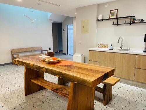 una mesa de madera en una cocina con fregadero en Rooms Homestay en Hualien