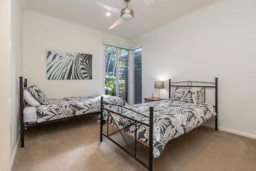 a bedroom with a bed and a chair at The Beach House at Lizzie in Elizabeth Beach