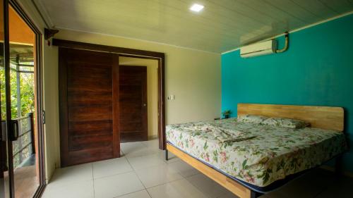 a bedroom with a bed and a blue wall at Green Leaf House in Fortuna