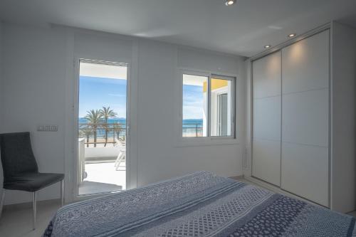 a bedroom with a bed and a chair and a window at Inmosantos Oasis F5 in Roses