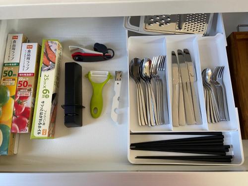 a drawer full of kitchen utensils on a shelf at Pleasure Point Ichinomiya in Ichinomiya