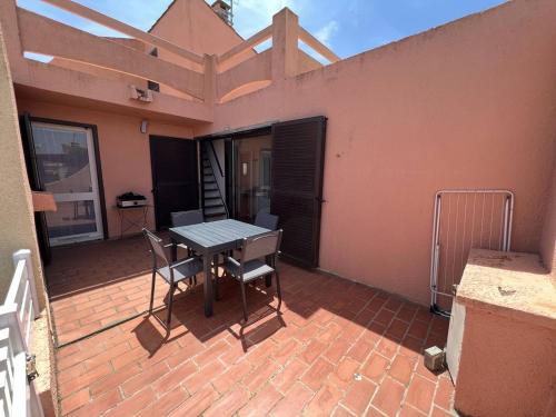 d'une terrasse en briques avec une table et des chaises. dans l'établissement Maisonnette 2 Pièces, 4 Pers, Face Mer, Clim, Parking - FR-1-81-597, à Leucate