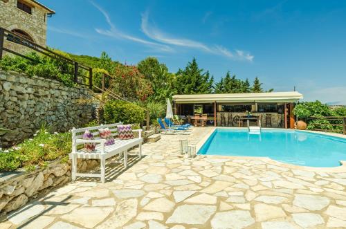 uma piscina num quintal com uma parede de pedra em Villa Poseidon Residence em Skinária