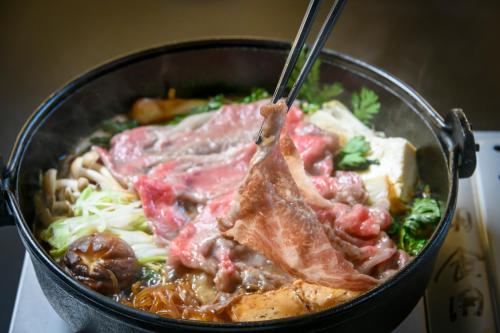 a bowl of food with meat and other ingredients at Hotel Symphony Annex Sagae Onsen in Sagae