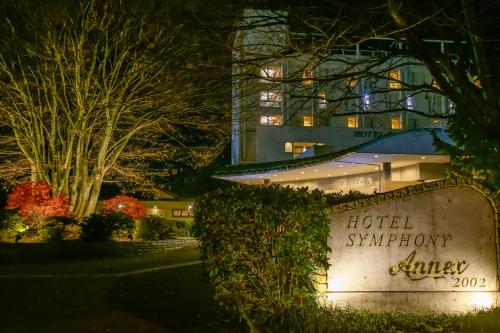 a hotel sign in front of a building at night at Hotel Symphony Annex Sagae Onsen in Sagae