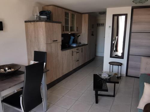 une cuisine et un salon avec une table et des chaises dans l'établissement Appartement cosy à 100m de la plage avec mezzanine, terrasse et parking privatif - FR-1-194-263, à La Tranche-sur-Mer
