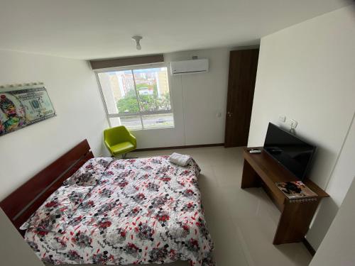 a bedroom with a bed and a desk and a window at Apartamento Valle de Lili in Cali