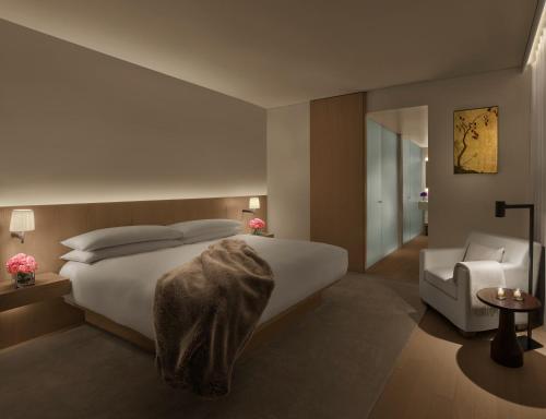 a bedroom with a white bed and a chair at The Tokyo EDITION, Toranomon in Tokyo