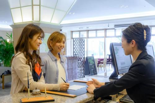 two women talking at a counter in an office at Hotel Symphony Annex Sagae Onsen in Sagae