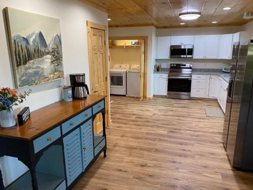 a kitchen with white cabinets and a wooden floor at Blue Sky Cabin - Built in 2023 this 3 bed 2,5 bath home has gorgeous views in Jefferson