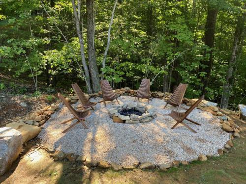 eine Gruppe von Stühlen, die um eine Feuerstelle herum sitzen in der Unterkunft Blue Sky Cabin - Built in 2023 this 3 bed 2,5 bath home has gorgeous views in Jefferson