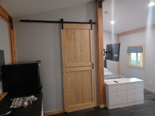 a bedroom with a wooden door and a bed at Wells Gray Stay And Play in Clearwater