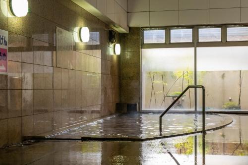 a pool of water in a room with a window at Hotel Symphony Sagae Onsen in Sagae