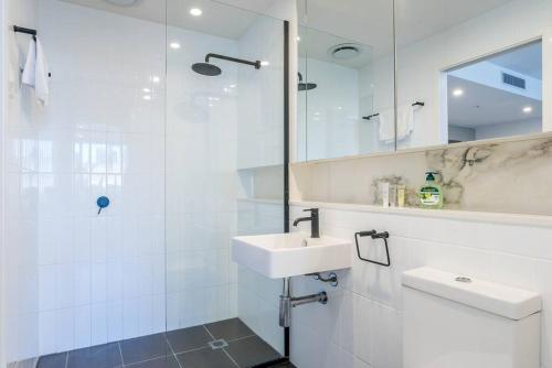 a white bathroom with a sink and a shower at South Bank Central 1 bedroom apartment with Parking in Brisbane