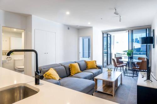 a living room with a blue couch and a table at South Bank Central 1 bedroom apartment with Parking in Brisbane