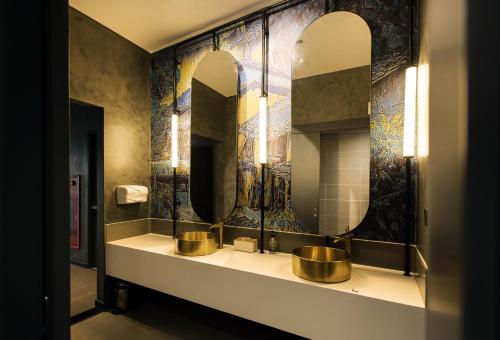 a bathroom with three sinks and mirrors on the wall at SOJO Hotel Lao Cai in Lao Cai
