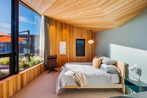ワナカにあるHideaway on Warren by Sotheby's Luxury Rental Homesのベッドと大きな窓のある寝室