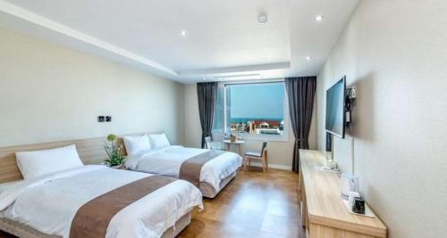 Postel nebo postele na pokoji v ubytování Jeju In Hotel