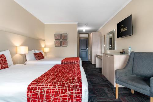a hotel room with a bed and a chair at Quality Hotel Parklake Shepparton in Shepparton