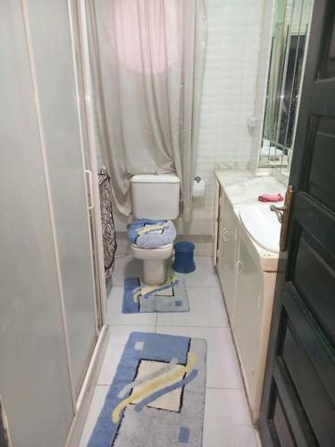 a bathroom with a toilet and towels on the floor at cousy apartment in Cairo