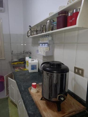 a kitchen counter with a pot on a wooden cutting board at cousy apartment in Cairo