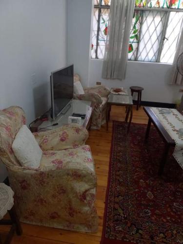 a living room with two couches and a tv at cousy apartment in Cairo