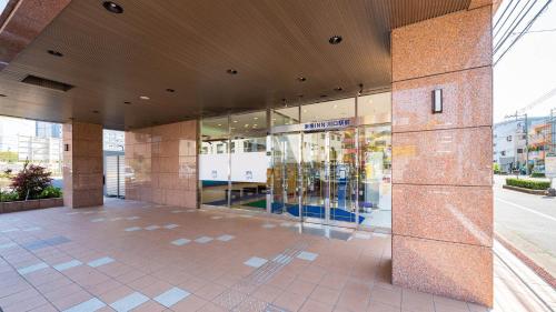 un bâtiment avec une façade de magasin avec des portes en verre dans l'établissement Toyoko Inn Kawaguchi Ekimae, à Kawaguchi
