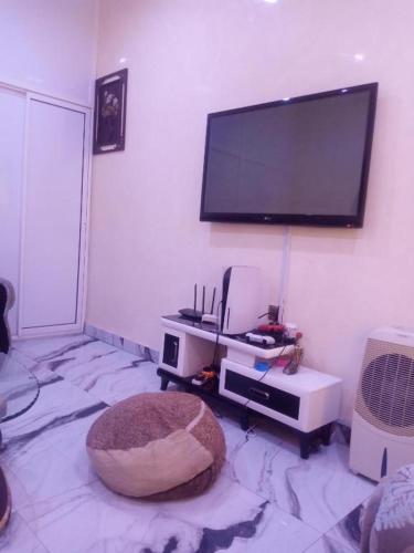 a living room with a flat screen tv on the wall at Delad Hotel and Suites in Ibadan