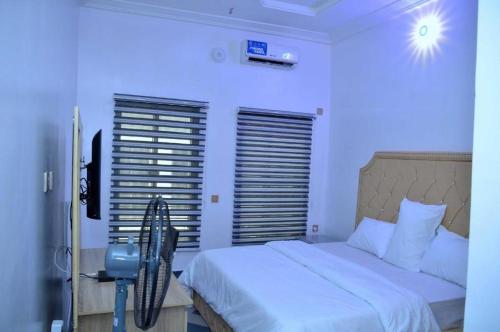 um quarto com uma cama grande e uma luz azul em Delad Hotel and Suites em Ibadan