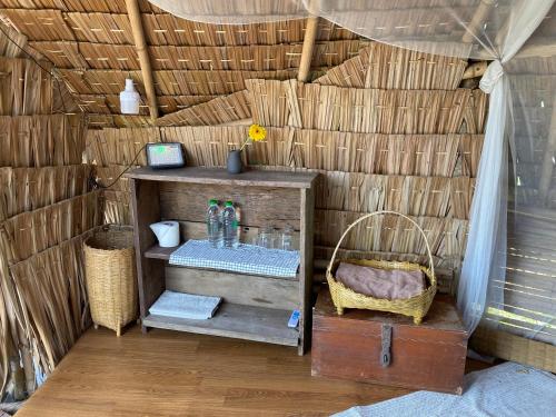 ein kleines Zimmer mit einem Regal in einer Strohhütte in der Unterkunft Royal mountain Hut in Ratchaburi