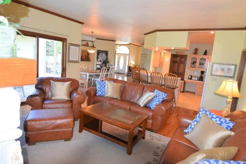 a living room with leather couches and a table at Carraig Nua House in Fish Creek