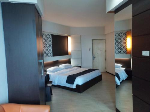ein Hotelzimmer mit einem Bett und einem Spiegel in der Unterkunft Hotel New Puri Garden in Kalibanteng-lor