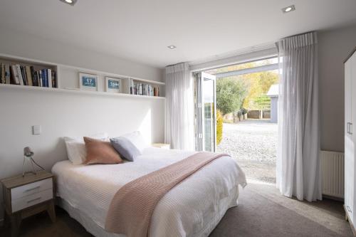 a bedroom with a bed and a large window at 61 Gibbston Valley in Gibbston