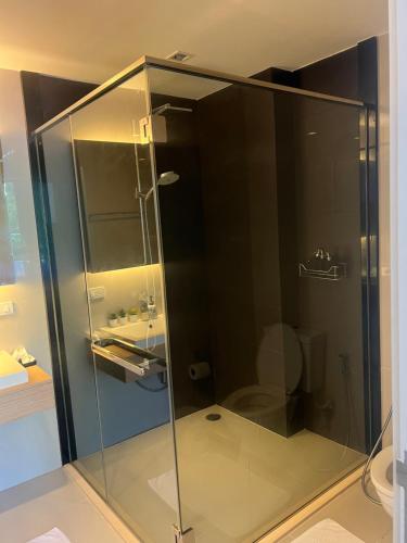 W łazience znajduje się szklana kabina prysznicowa i umywalka. w obiekcie Deluna 23degree by The valley khao yai w mieście Pak Chong